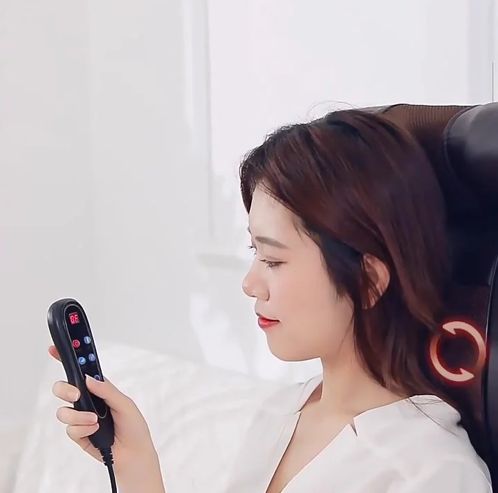 Person seated on the massage mattress holding the handheld remote